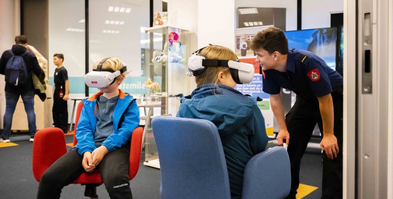 Bezoekers kijken met een Virtual Reality-bril of ze de goede keuzes maken bij de brand in huis.